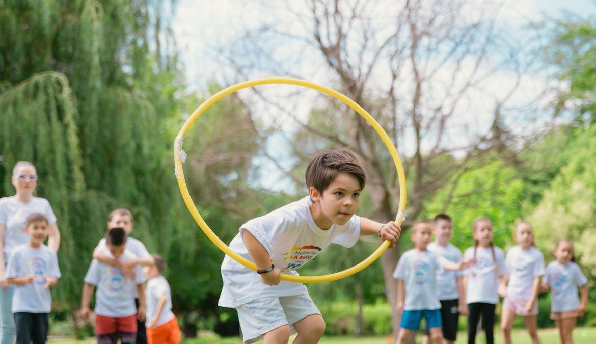 Kids enjoying a summer day playing with hula hoops in a park, showcasing friendship and fun.